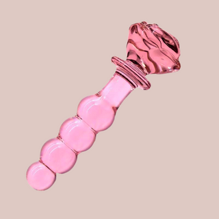 An angled view of the rose pink glass beaded dildo, you can see how the rose base is shaped to be held.