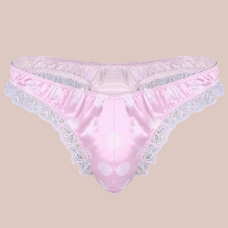 A soft pale pink satin mens female style knickers. They have a white spot design on the pink fabric, white lace edging to the legs and a thong style back.