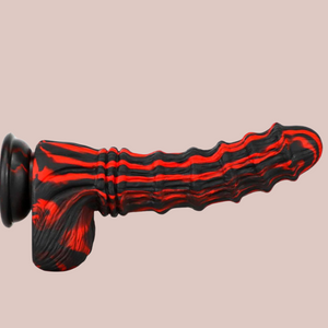 The Fire Monster Dildo attached to a surface, you can see the red and black striping and he raised ring design.