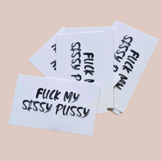 A pile of Fuck My Sissy Pussy temporary tattoos, this image gives an idea of the size and style of lettering on the tattoos.