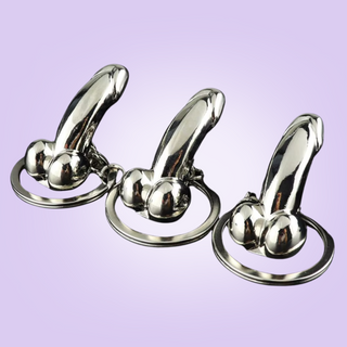 Another view of a trio of key rings sitting on their base with the penis attachment looking erect.