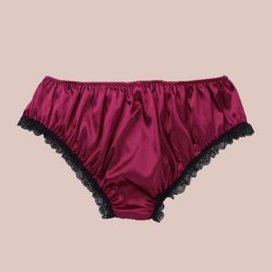 Back view, Adult knickers for men, sissy, lgbt, unisex. Made in red wine satin with black lace detailing to the legs and panels on each side. There are also matching red wine satin bows prettily applied.