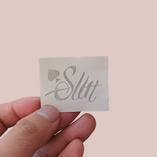 An image of the Slut temporary tattoo from House of Chastity before it is applied, please note that it will be back to front when you read it.